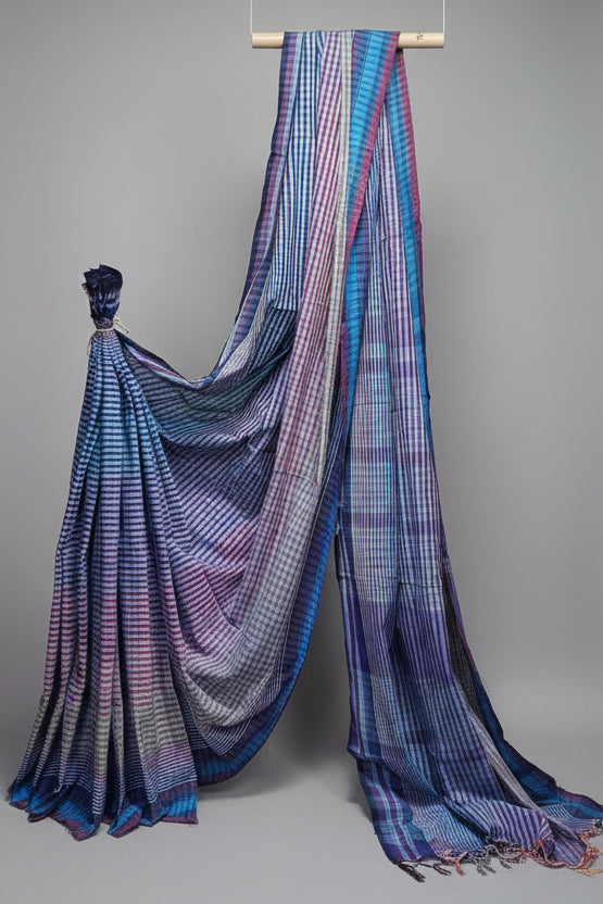 Blue and purple checkered saree draped over a stick against a white background