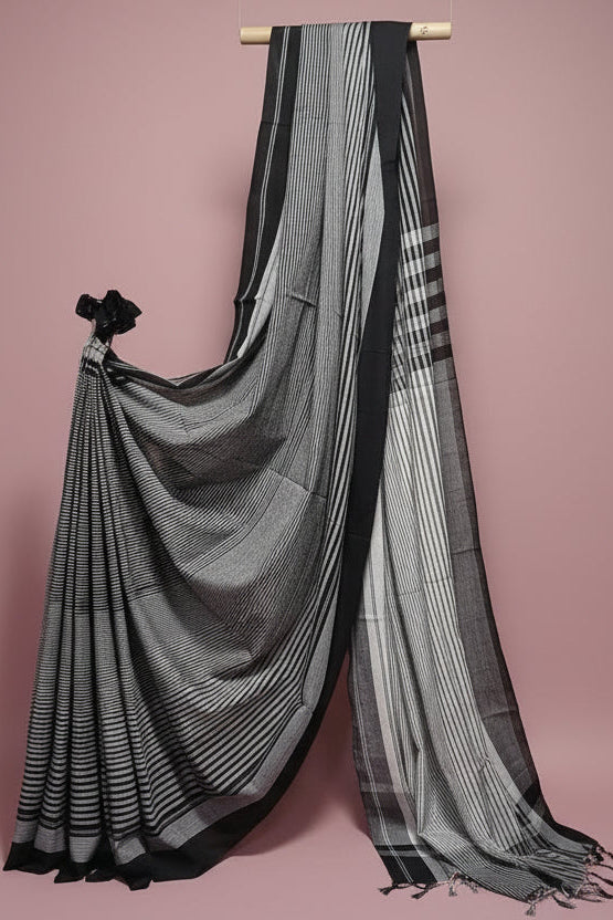 Black and white striped saree draped over a white background