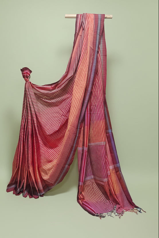 Colorful striped saree draped over a stick against a white background
