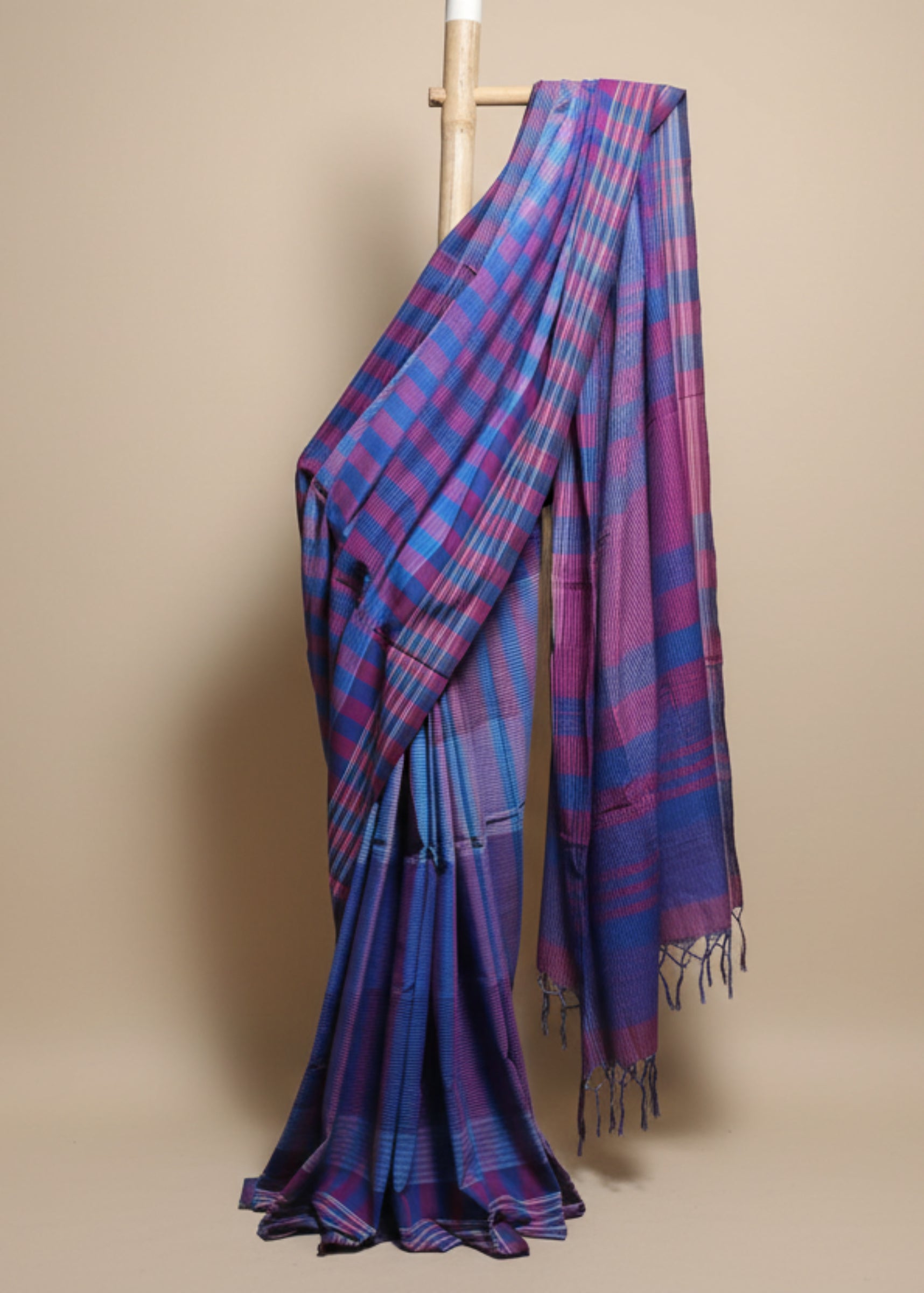 Blue and pink plaid fabric draped over a white background