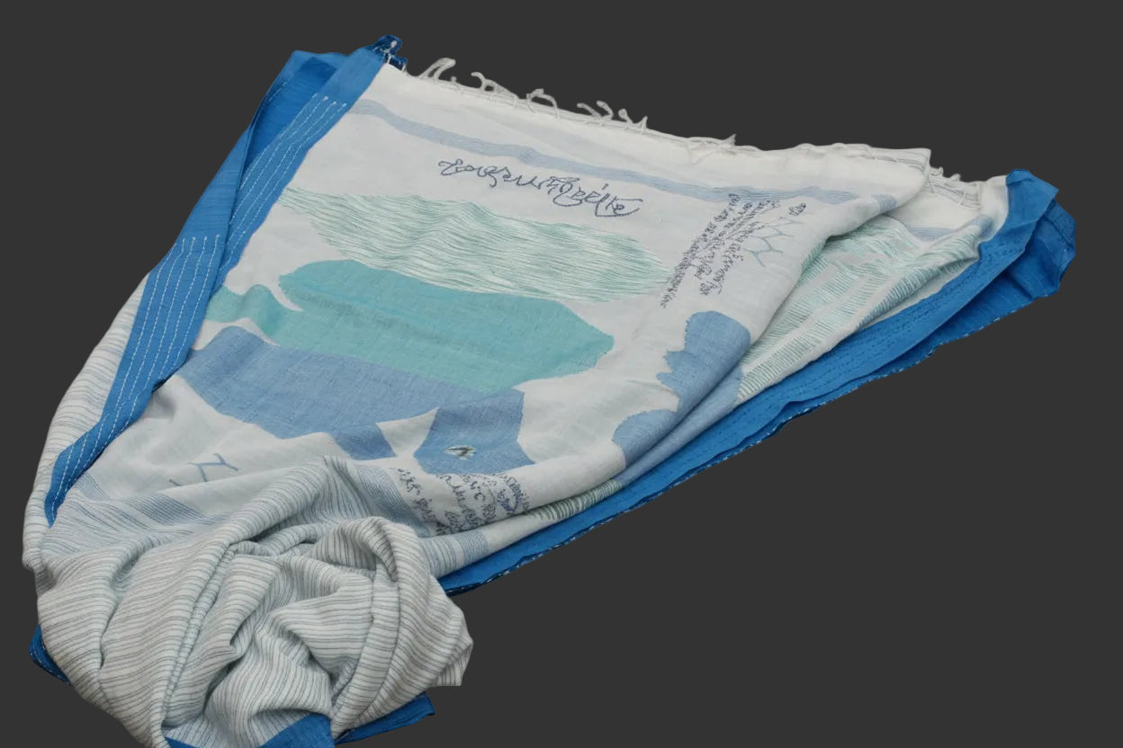 Folded fabric with a blue and green design on a dark surface