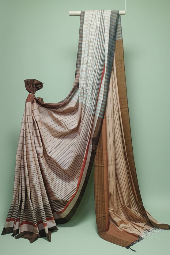 Brown and beige patterned saree draped over a white background