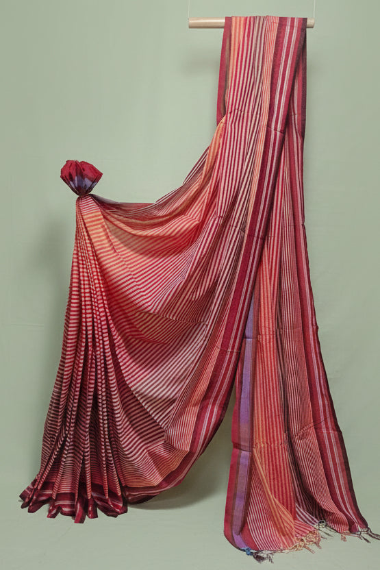 Red and purple striped saree draped over a white background
