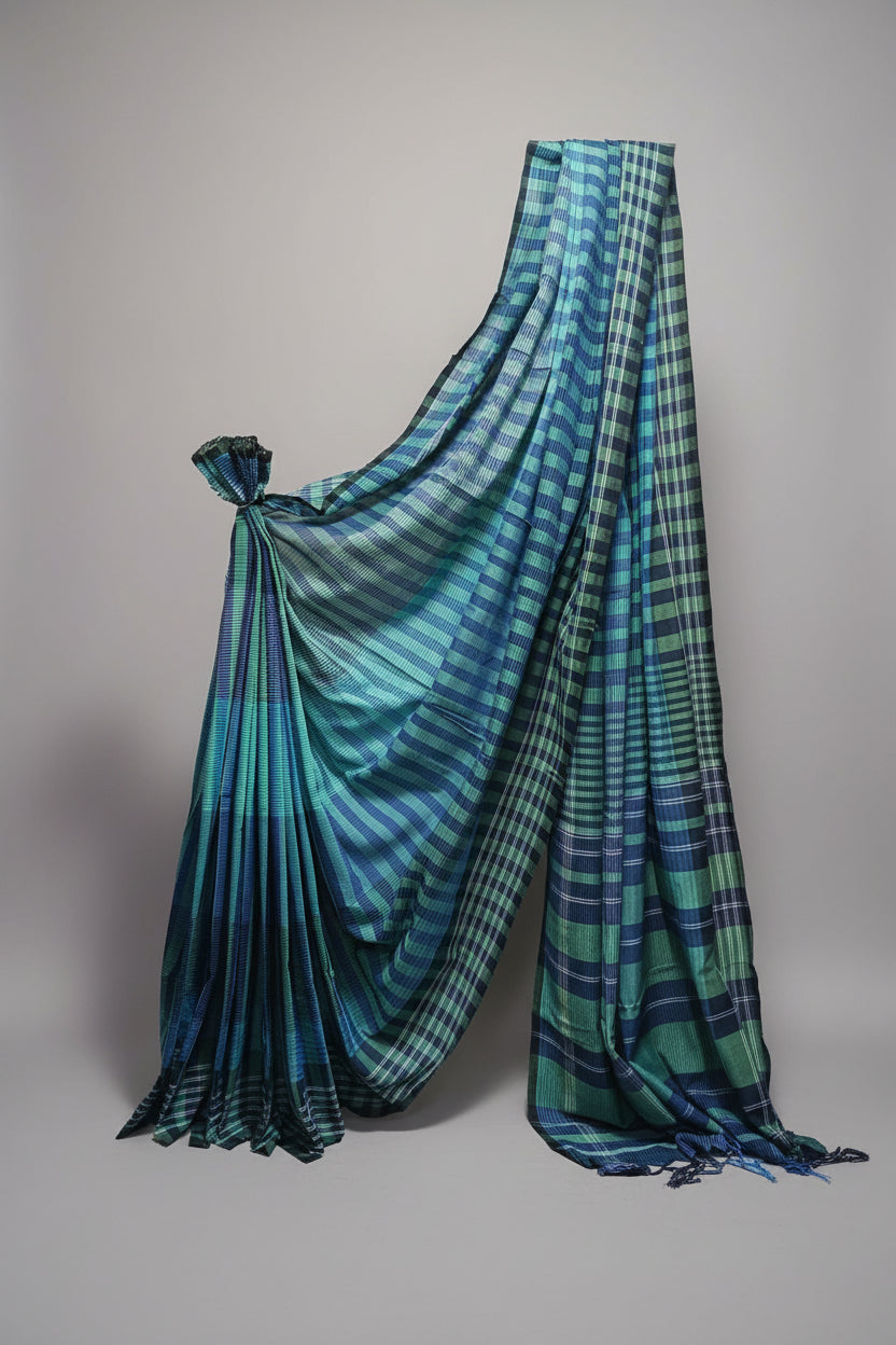 Blue and green plaid saree draped over a white background