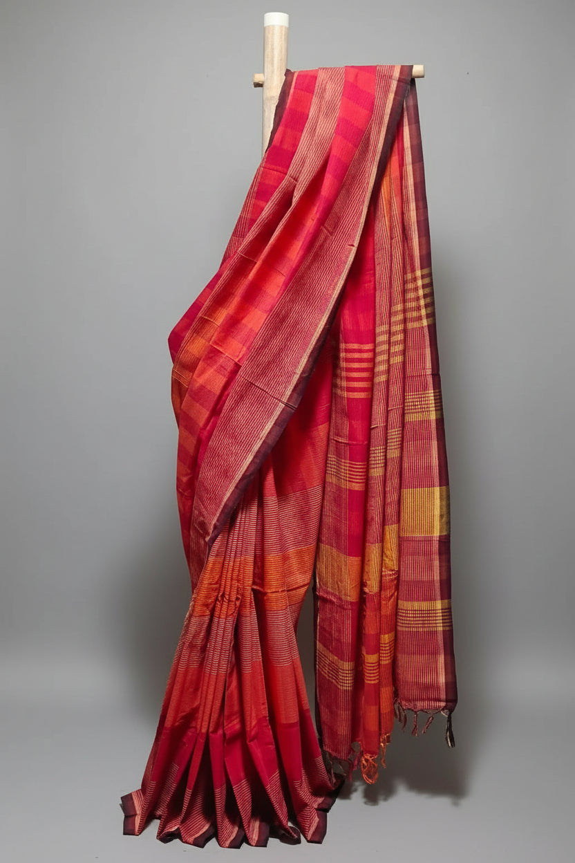 Red and orange plaid fabric draped over a mannequin against a white curtain.
