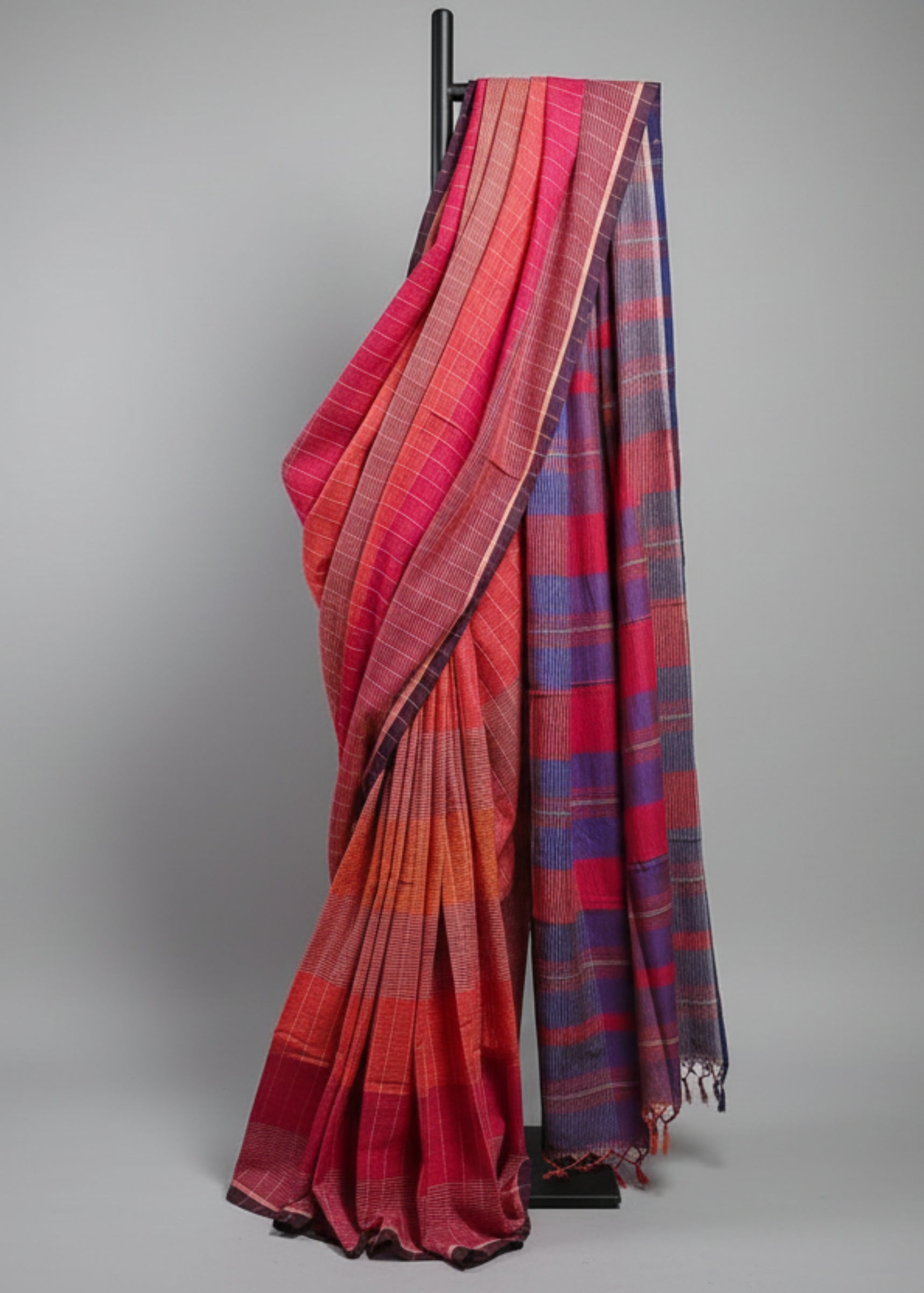 Red and blue plaid saree draped over a white background