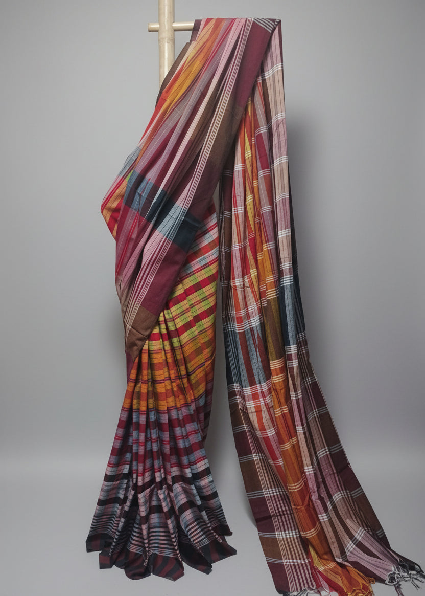 Colorful plaid fabric draped over a wooden rod against a white background